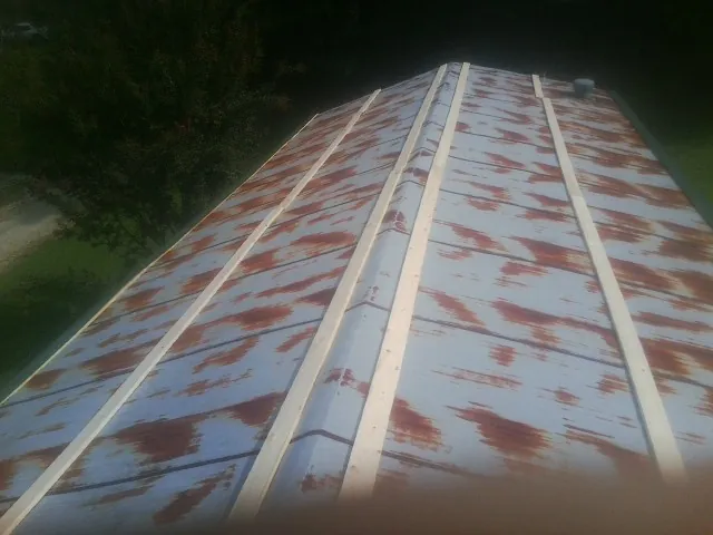 Rusted metal roof panels with new wood purlins before replacement — Storm Damage Roof Repair in Dorset by Roofing Brothers